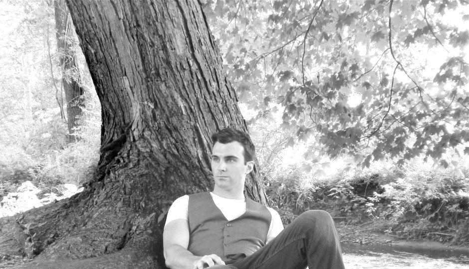 Matthew James sitting next to a river bank