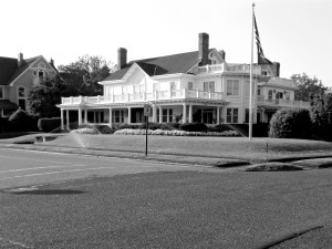 A fairly utopian scene with sprinkles watering a perfectly manicured yard.